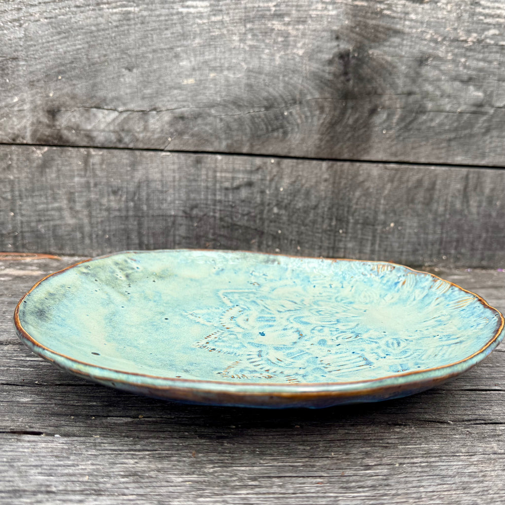 Blue ceramic plate with textured design on a wooden surface
