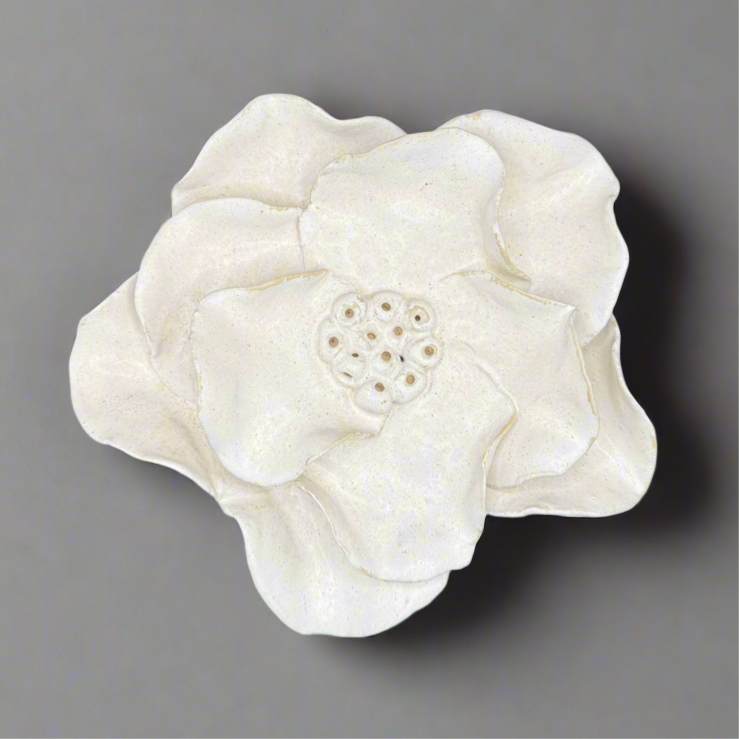 White ceramic flower on a gray background