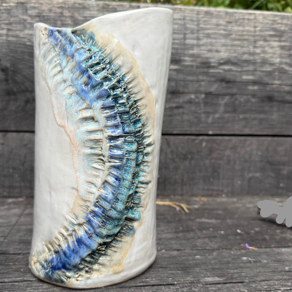 Ceramic vase with ocean design on a wooden surface
