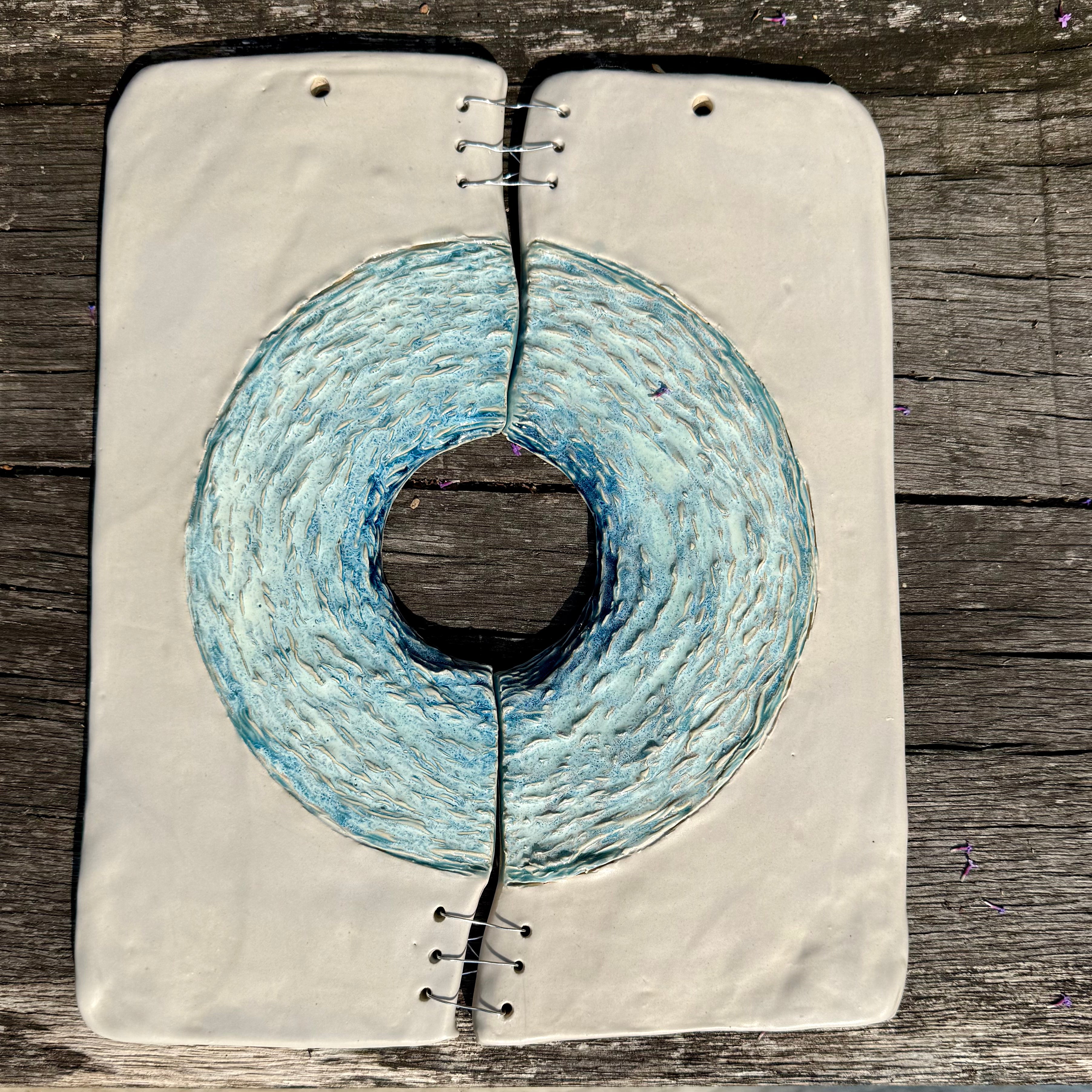 Artistic depiction of a circular ceramic design on a textured surface with a wooden background