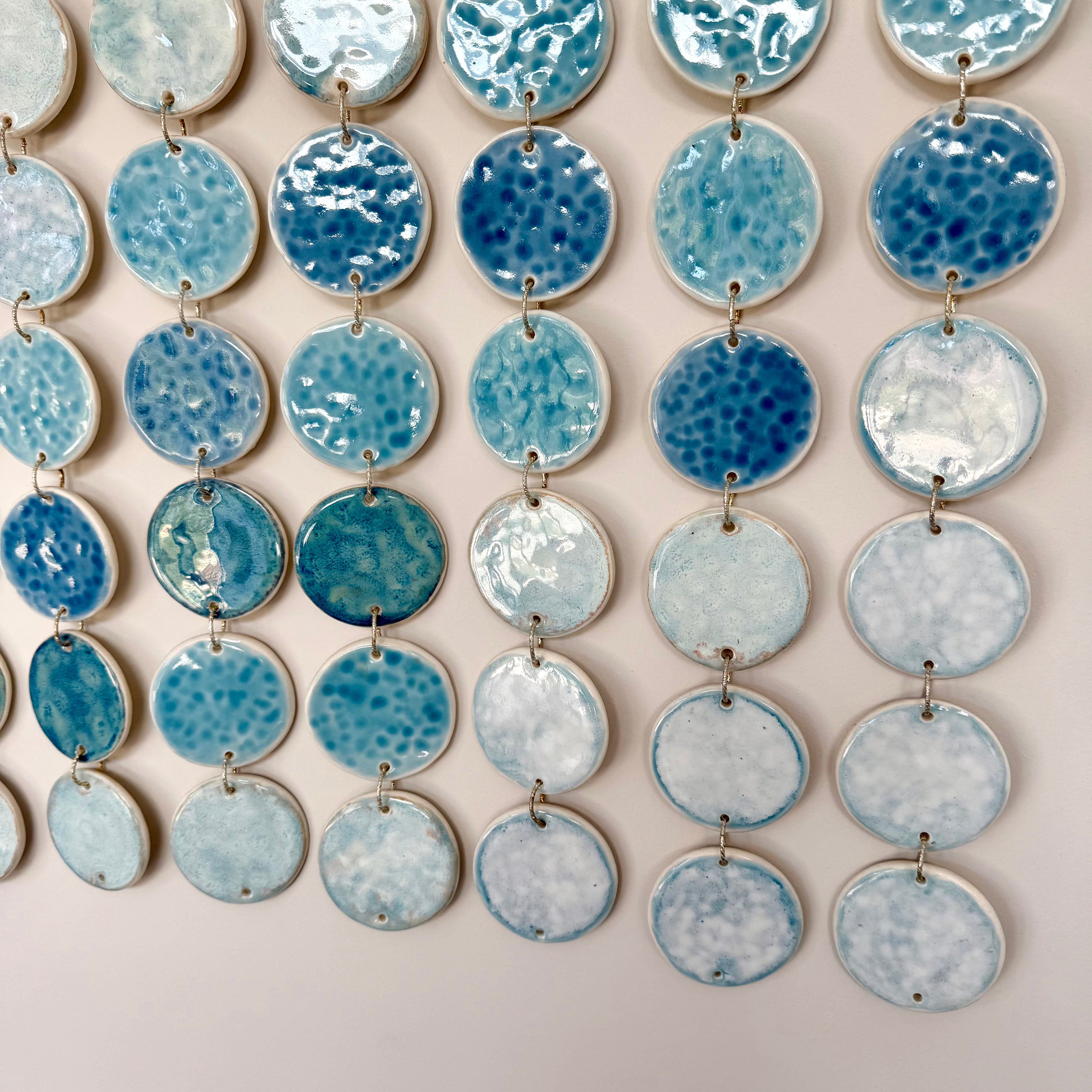 String of blue and white ceramic discs on a beige background