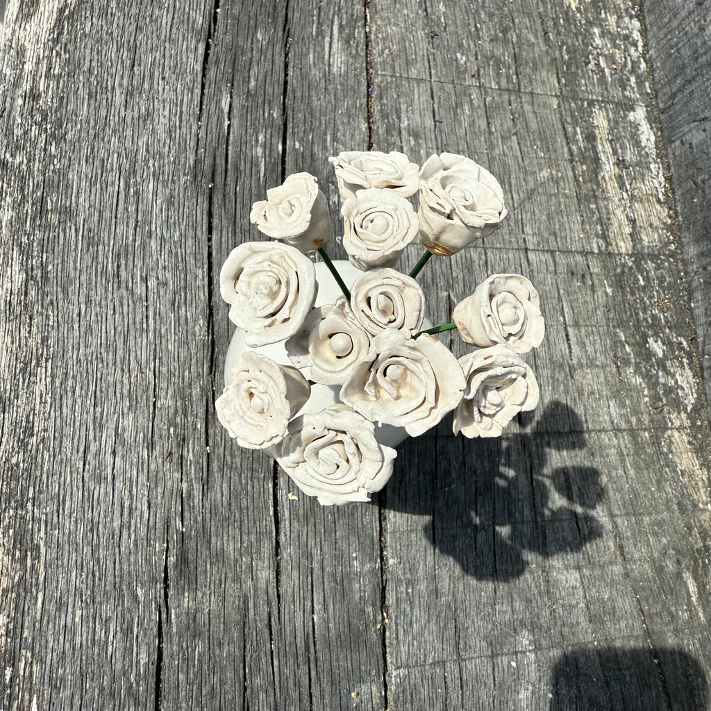 White ceramic flowers on a wooden surface